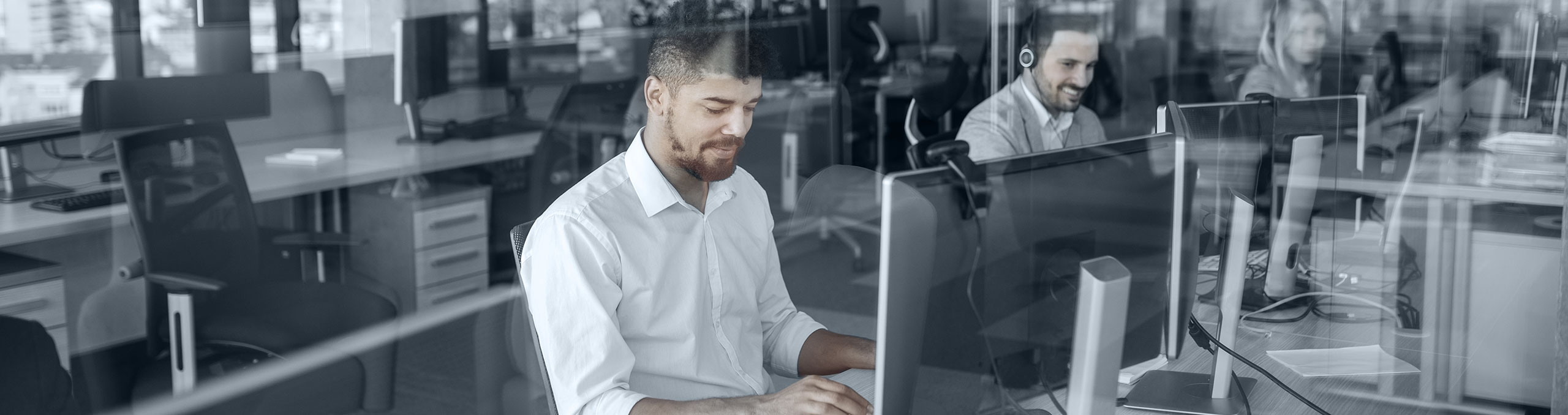 Men sitting, working on computers at their desks in an office
