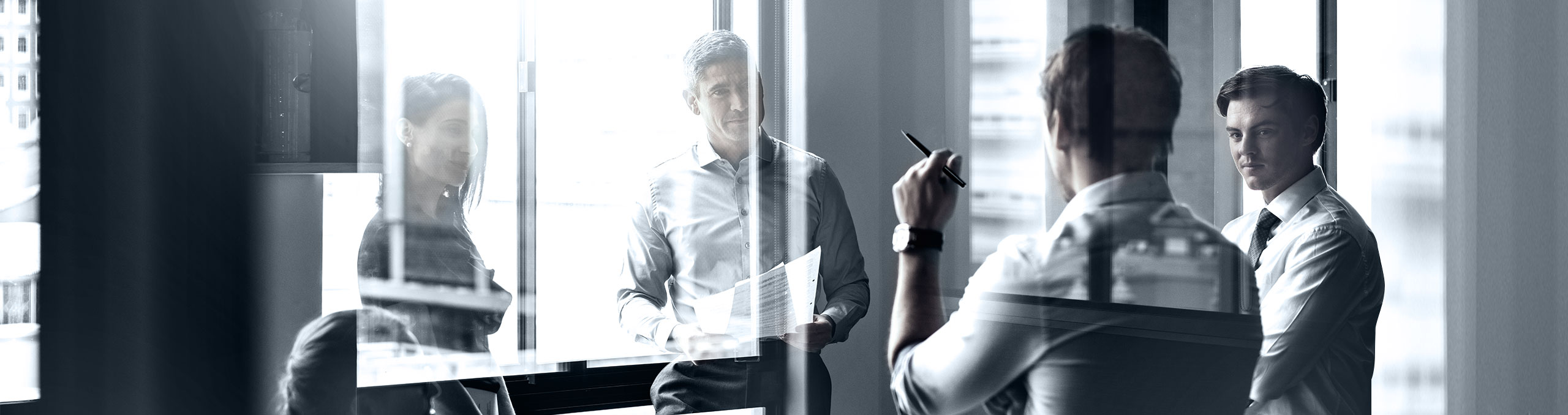 Four people standing in office discussing business